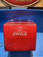 Top view of cooler showing CocaCola logo and handle with bottle opener