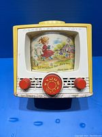 Front view of the 1965 Fisher-Price Mary Had a Little Lamb music box showing turn dial, knobs, and illustrated window.