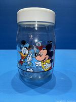 Front view of clear glass jar showing Mickey Mouse and Donald Duck painted on the side