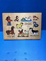 Top view of the wooden Fisher Price Farm Animals puzzle board showing all nine animal pieces in place.