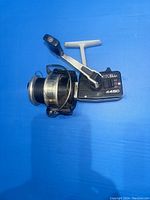 Side angle view showing Mitchell 4450 vintage fishing reel with visible line on spool, handle arm, and bail arm.