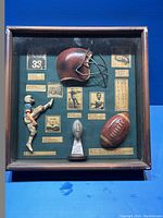 Front view showing entire shadow box with all memorabilia items mounted on green felt background under glass.