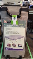 Front view of Ozark folding queen bed in a soft carrying case showing product label with features and images of the bed unfolded and in use.