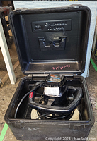 Orbital car waxer inside protective carrying case, showing the tool with handle and waxing pad.
