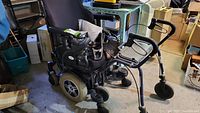 Quantum electric power wheelchair with joystick control, black cushioned seat and backrest, visible wheels and structure