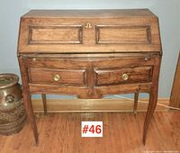 Front view of drop front desk closed showing serpentine drawer fronts, molded panel drop front and cabriole legs