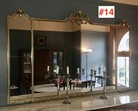 Full frontal view of three-panel mirror on marble top with silver candelabra