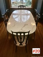 Overhead front view of oval marble-top table and six chairs in front of window