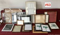 Assorted picture frames arranged on red fabric surface showing variety of sizes and styles including wood and metal frames.