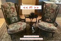 Pair of wingback chairs in room with small table