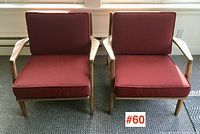 Front view of both teak armchairs with deep red cushions