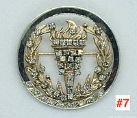 Full front view of brooch showing wreath and torch motif with diamond accents