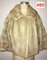 Front view of a beige ladies mink fur jacket on a mannequin, showing the full jacket including collar, sleeves, and closure.