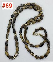 Full view of the tiger eye and gold bead necklace laid out flat showing clasp and length.
