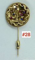 Front view of stick pin showing tree of life motif and colored stones