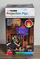 Boxed Gemmy LED Light Show Projection Plus with promotional images showing the effects including whirl-a-motion and static multicolor light projections with a 15 ft cord.