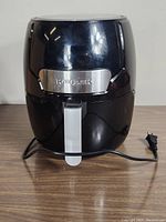 Black Kalorik digital air fryer with front view showing handle and power cord.