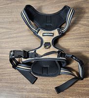 Front view of brown and black Rabbitgoo no-pull dog harness with reflective straps, padded areas, plastic buckle, and metal D-ring.