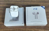 White Saich i12 wireless earbuds inside white charging case in original packaging box showing product label and earbuds image.
