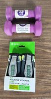 Photo shows two purple neoprene 3 lb hand weights and packaged pair of Gaiam walking weights labeled 4 lb each.