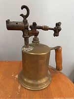 Front and side view of antique brass blow torch showing main body and handle