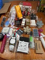 Full overview of assorted beauty and skincare products and accessories arranged on a wooden table.