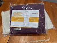 Photo shows three unopened full length hanging coat organizers in packaging, one in purple and one in beige color, with labels showing product details.