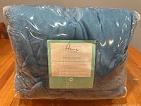 Front view of packaged blue mink sheet set showing Home Suite label with product details.