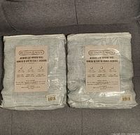 Two packages of Hudson & Main Jacquard Leaf Window Panel curtain panels, new with product label visible