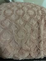 Close-up of blanket surface showing raised circular textured fleece in light brown/beige color.