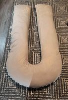 U shaped beige body pillow laid flat to show full shape and size.