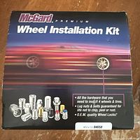 Front of sealed McGard wheel installation kit box showing branding and image of lug nuts and bolts.