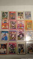 Full lot of 17 assorted sports cards shown in protective cases, displaying a variety of players and card designs.