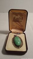Nephrite jade pendant necklace in open box marked Ariki 22 Carat Gold Plate Nephrite Jade