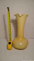 Full view of the yellow opalescent fluted vase with a measuring tape showing height approximately 12 inches.