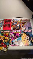 Photo showing front covers of 8 comic books including 3 Wolverine, 1 Venom, and 1 Sabretooth issue among others.