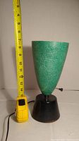 Mid-Century Modern green fiberglass table lamp next to measuring tape showing height of about 12.5 inches.