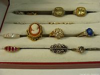 Photo showing all 12 rings arranged in a cream velvet ring box with visible variety in styles and stones.