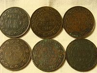 Photo showing six Canadian one cent coins dated 1876, 1907 (3 coins), 1916, and 1918 with varying patina and wear.