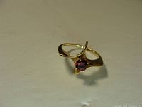 Front view of the gold garnet ring showing gemstone and band design.