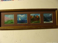 Full view of the framed artwork showing four small paintings representing spring, summer, autumn, and winter, behind glass.