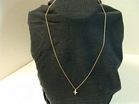 Full view of 17-inch delicate gold chain necklace with small cross pendant.