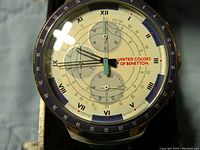 Close-up image of the watch face showing the cream dial, Roman numerals, chronograph sub-dials, and blue and white bezel.