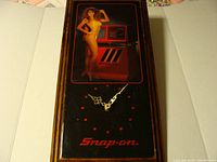 Full view of Snap-on wall clock showing the clock face, hands, and Snap-on logo below, with some scratches visible.