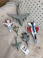 Overall view of the six airplane models placed on a light surface with a perforated board background, showing scale and detail.