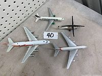 Four civilian model airplanes on fabric surface showing details and branding