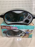 Photo of the Easy Bake Oven on its original box showing front door with blue swirl designs and control dial.