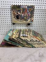 View of 17 Giles cartoon books stacked side by side with visible spines and front cover of one book titled 'Cartoons 2003'