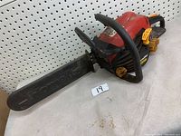 Full view of the Homelite 3514c chainsaw, showing 14-inch black bar with 'Homelite' embossed, red body, black handles.