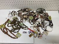 Collection of wood bead and natural material necklaces, bracelets, and keychains spread on white surface.